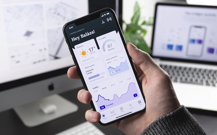 Hand holding a phone showing a mobile app dashboard